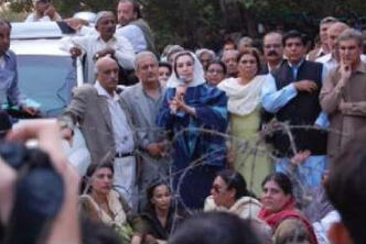 Bhutto (center) speaking to supporters outside her house, November 2007