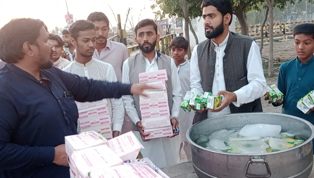 The welfare team is distributing Iftar packs among the passengers.
