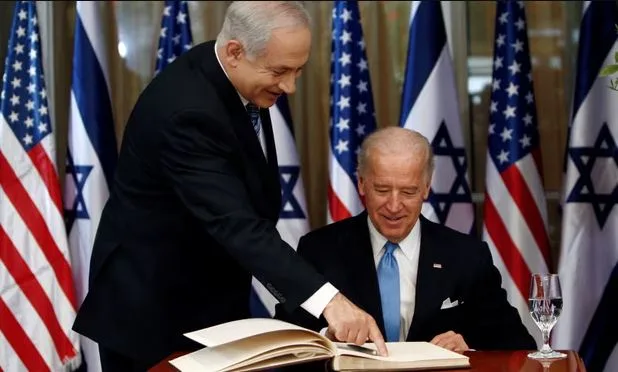 Benjamin Netanyahu indicates Joe Biden’s next move as the then vice-president signs the guest book at the Israeli prime minister’s office in Jerusalem in 2010. Photograph: Ronen Zvulun/Reuters