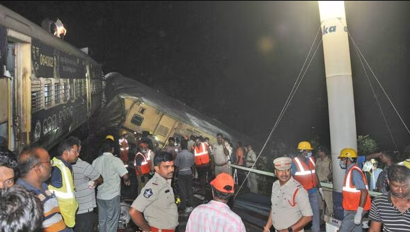 Andhra train accident: Rescuers and others stand after two passenger trains collided in Vizianagaram district. The crash happened when an incoming train slammed into a stationary train, leading to derailment of at least three rail cars. (AP Photo)